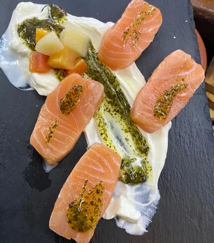 Lomitos de salmón ahumado con salsa de yogur y menta sobre pizarra